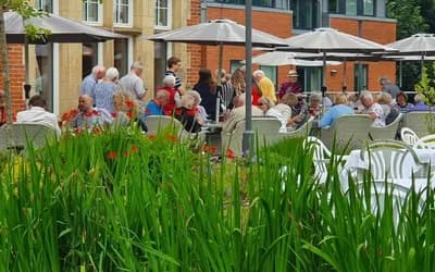 Residents stood around outside at a BBQ