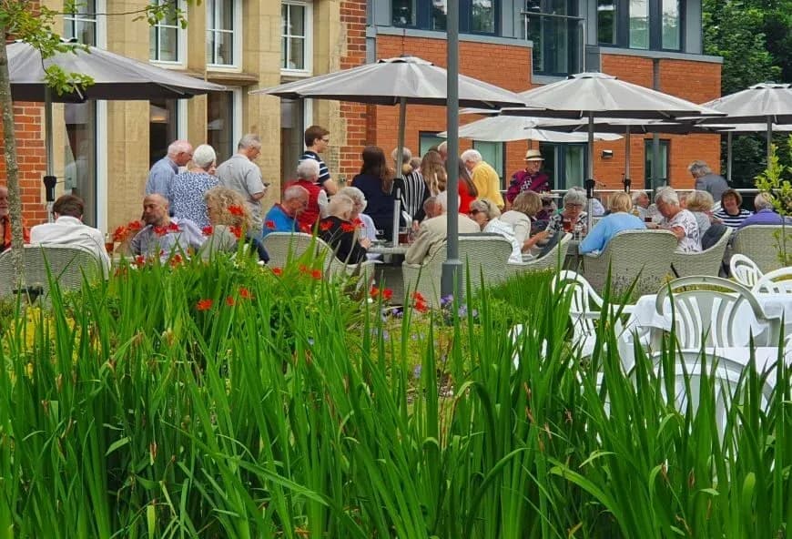 Residents stood around outside at a BBQ