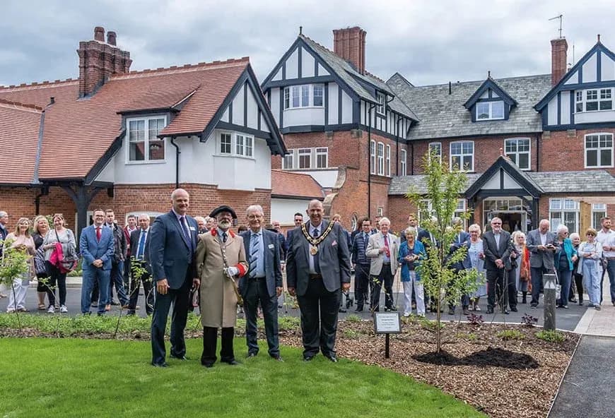 Lots of people outside red house celebrating.