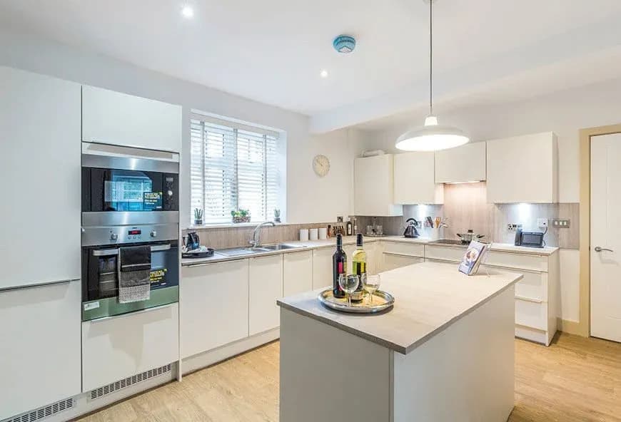 A grey and white kitchen with an island.
