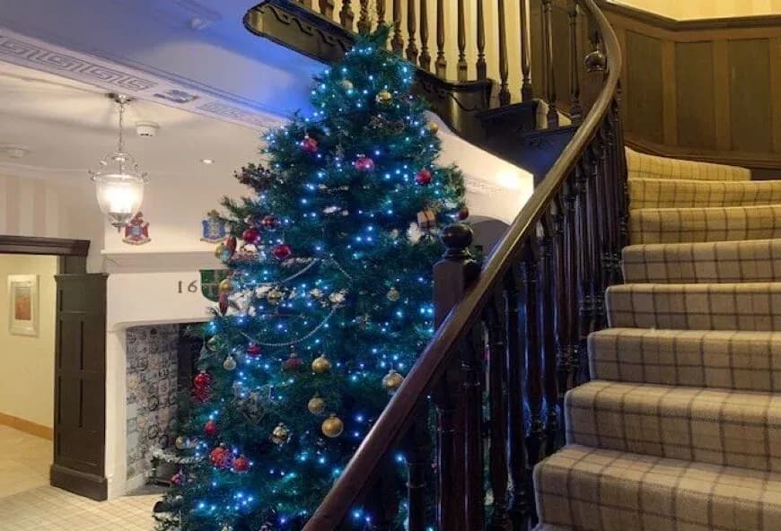 Christmas tree by a sweeping staircase