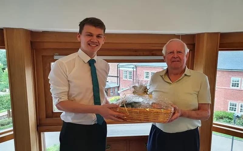 Staff presenting a gift hamper to a resident