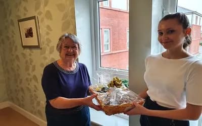 Staff presenting a gift hamper to a resident