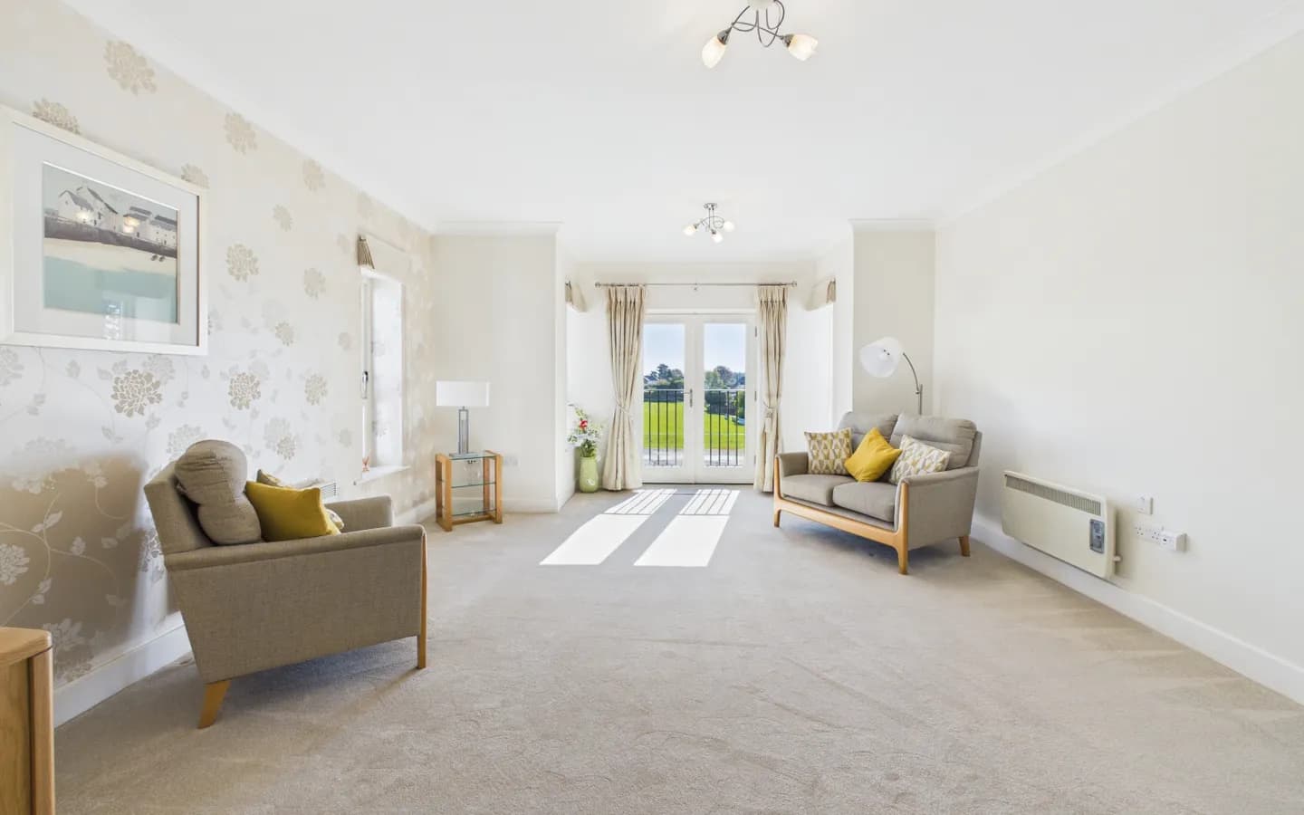 Living room in Apartment 19 Boughton Hall with french doors overlooking the cricket club.