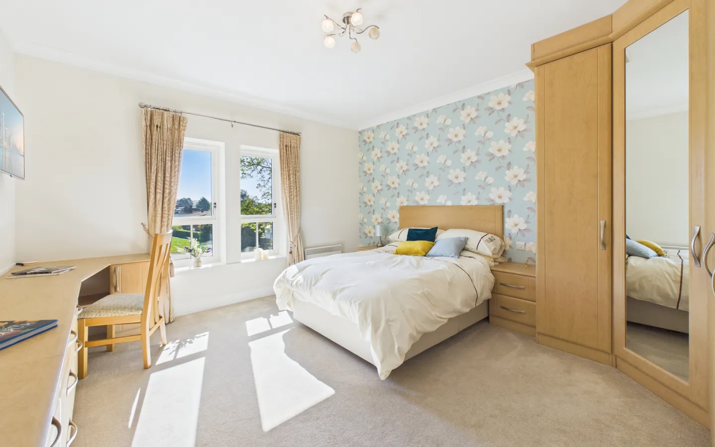 The bedroom in Apartment 19 Boughton Hall with views over the cricket club from the window.