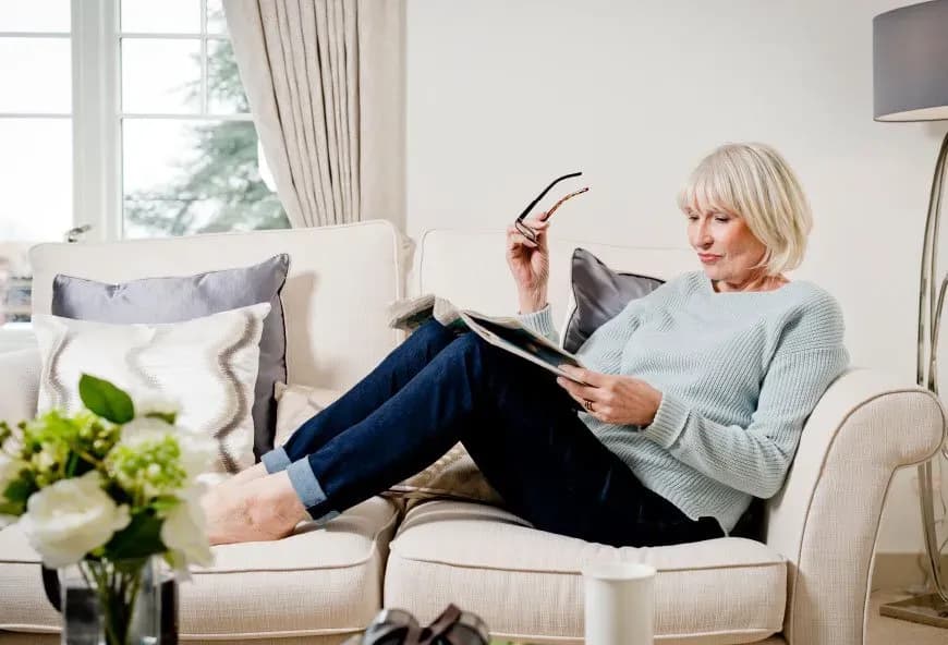 Women reading a magazine on a sofa