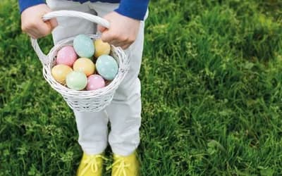 A basket full of multi coloured easter eggs .