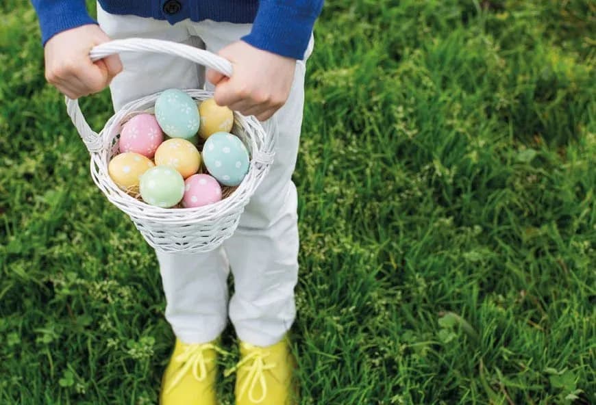 A basket full of multi coloured easter eggs .
