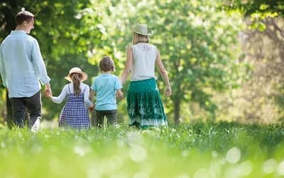Family in a field with hats and daisies
