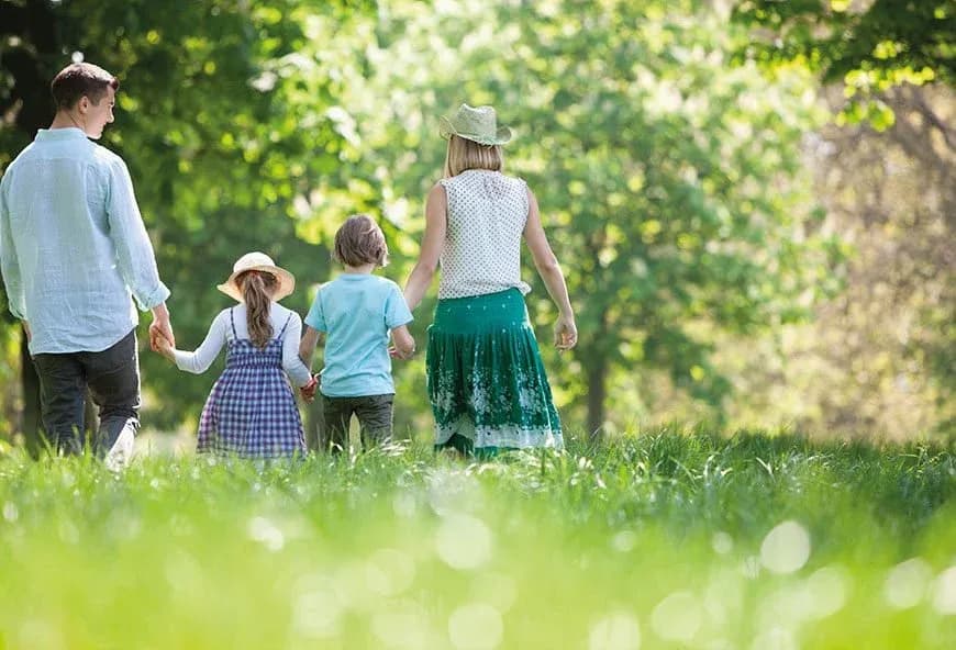 Family in a field with hats and daisies