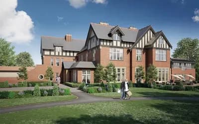 The outside of a large detached building with brick and black windows