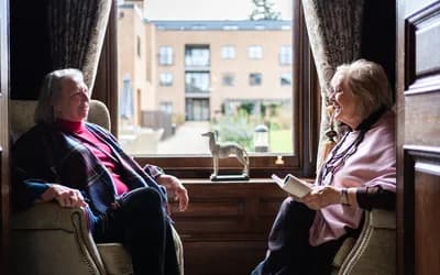 Residents sat by a window chatting
