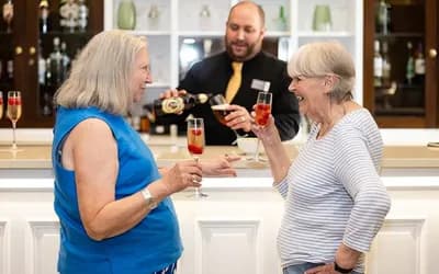 Two women with a drink cheering