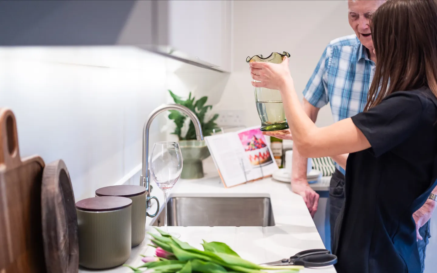 Staff helping a resident put flowers into a vase