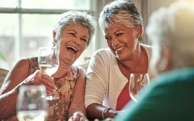Two older women drinking wine and smiling