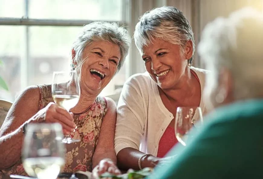 Two older women drinking wine and smiling
